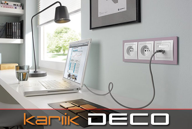 Gniazdka i łączniki Karlik Deco w ramce pastelowej zamontowane w nowoczesnym biurze z białym biurkiem i laptopem.